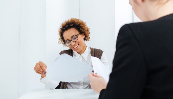 Smiling african american young businesswoman having job interview and filling application in office